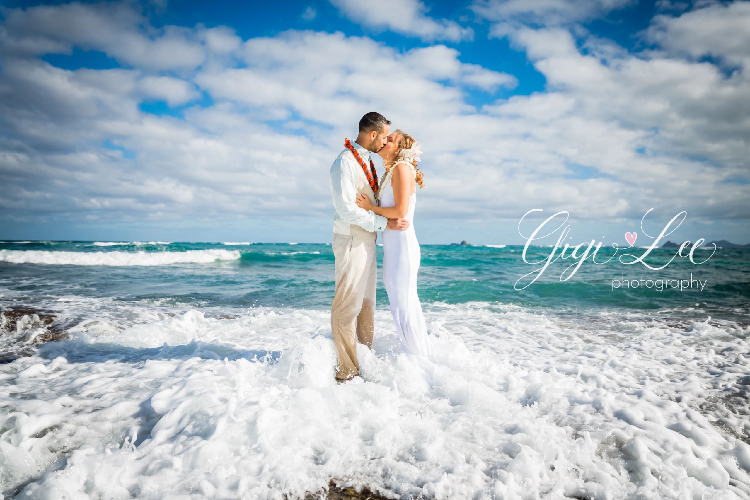 Couple kissing in ocean waves Hawaii wedding